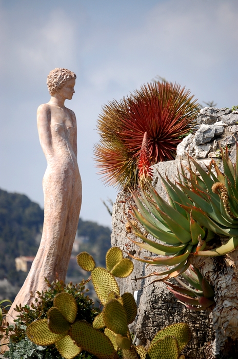 Statue et végétation méditerranéenne dans un jardin du littoral, illustration d’un paysage façonné par le climat et la roche.